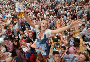 Woman wearing traditional German Oktoberfest lederhosen at Munich beer tent celebration.