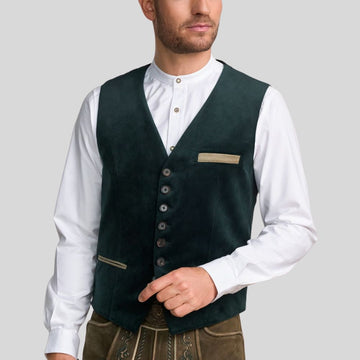 Man wearing a dark green vest over a white shirt on a gray background