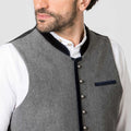Gray vest with black trim worn by a person on a light gray background