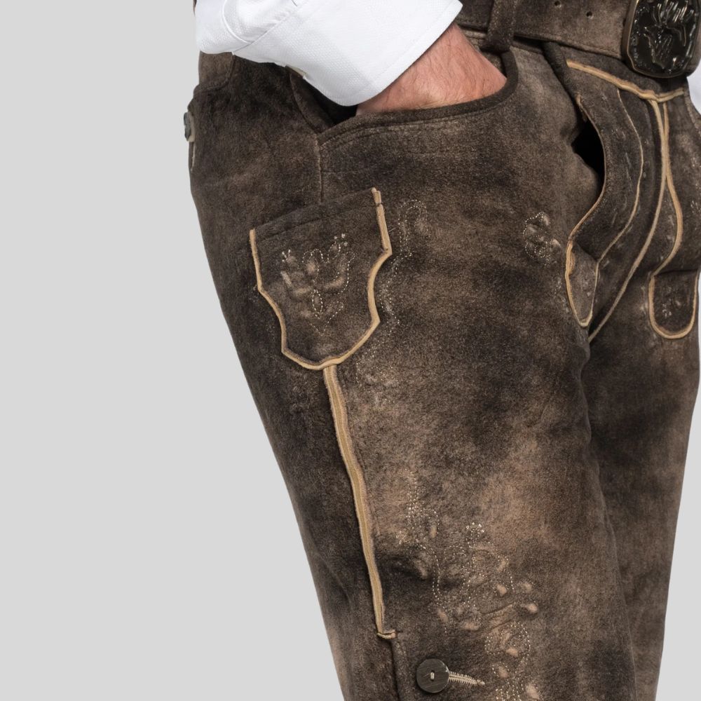 Brown leather pants with beige stitching on a light gray background
