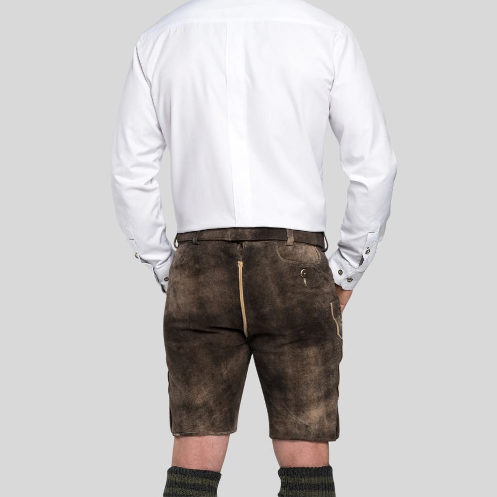 Person wearing brown leather shorts and a white shirt on a gray background