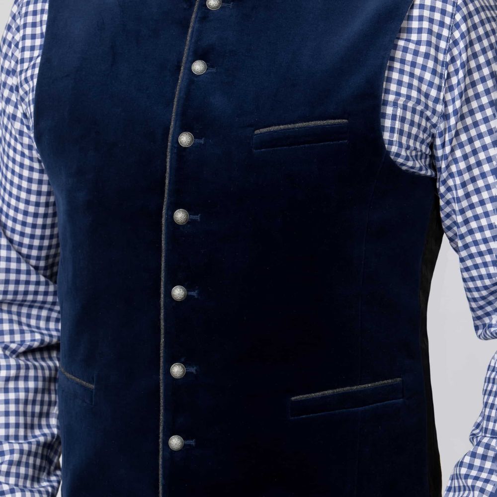 A dark navy blue velvet waistcoat with a mandarin collar, decorative silver-tone buttons down the front, and welt pockets, shown against a solid gray background.